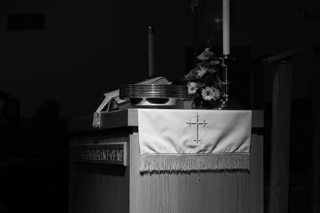 altar with candle and cross cloth draped over